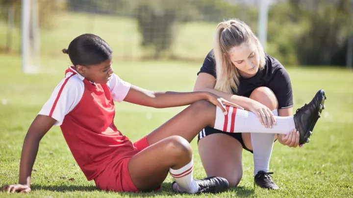 Injured soccer player sitting on field