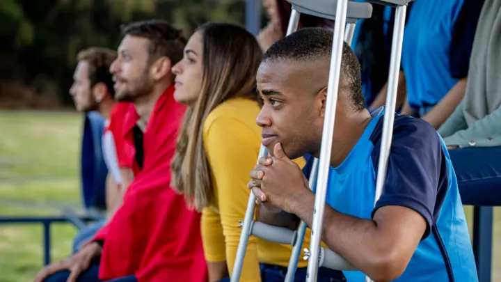 Injured soccer player sitting on the sidelines