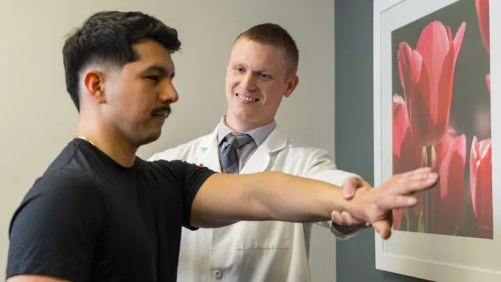 Sports medicine physician evaluating patient's arm