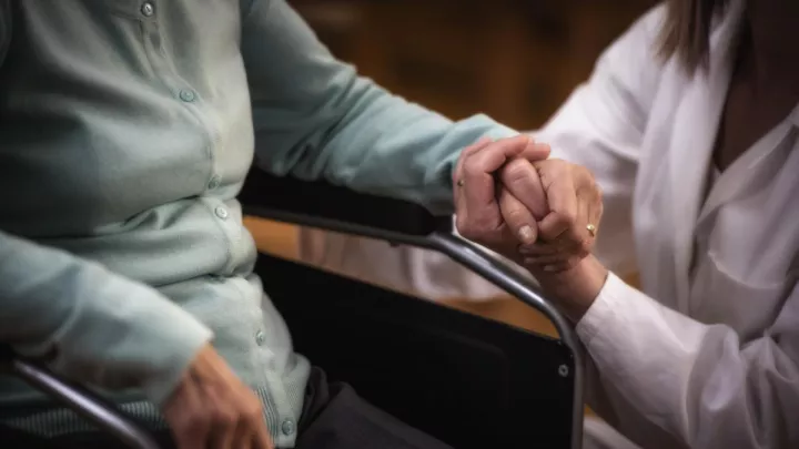 Close up of doctor holding woman's hand