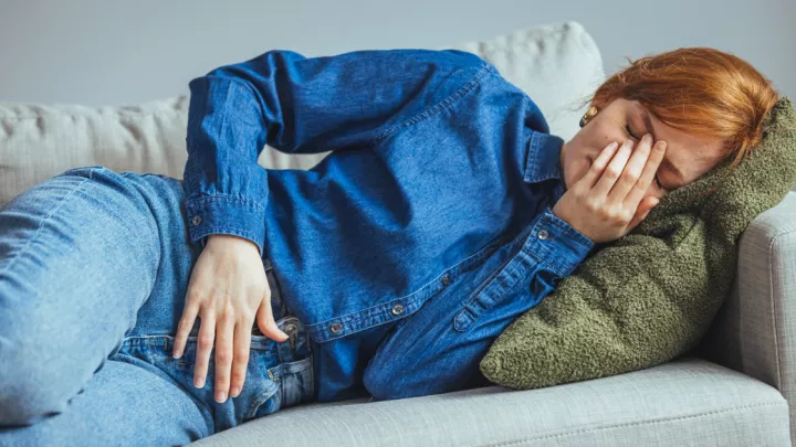 Woman laying on couch with pelvic pain