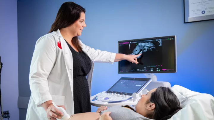 Dr. Rimsza showing an ultrasound image to pregnant woman