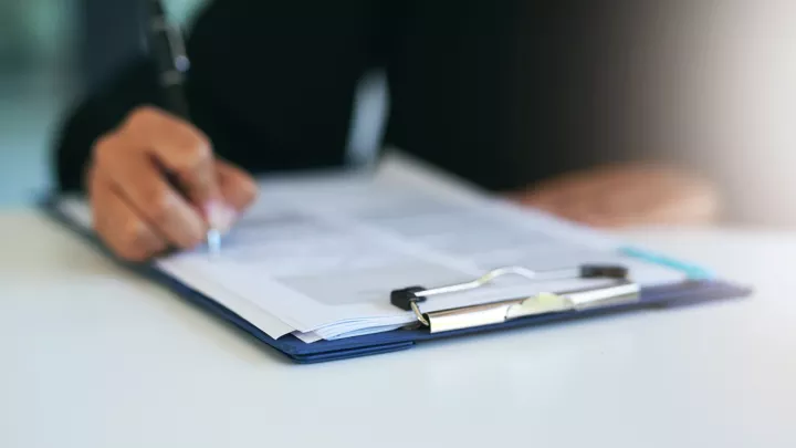 Close up of person signing forms