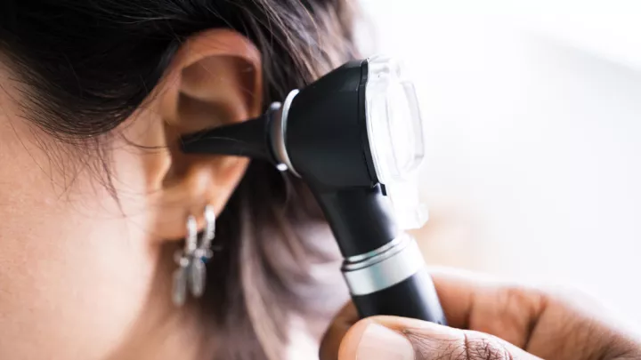 Scope looking in woman's ear