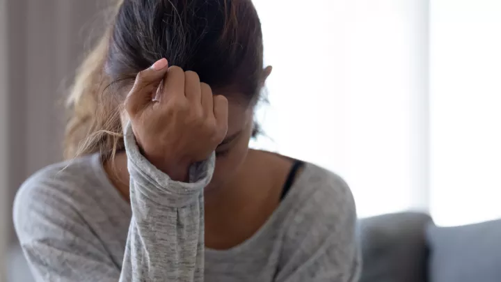 Woman holding her head in her hand