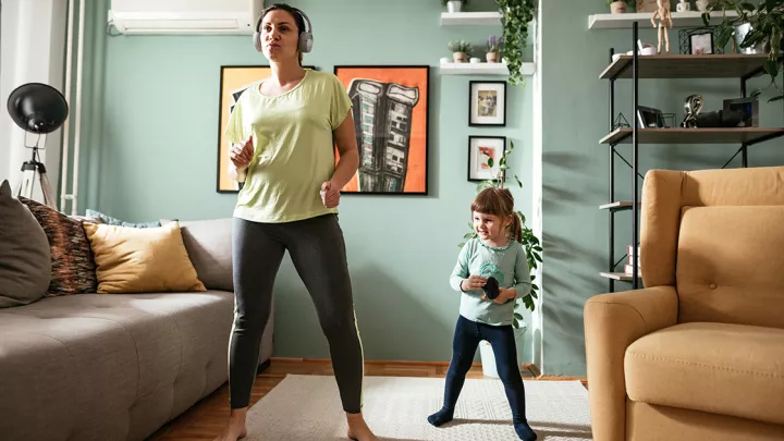 Mom and young daughter doing home workout in living room