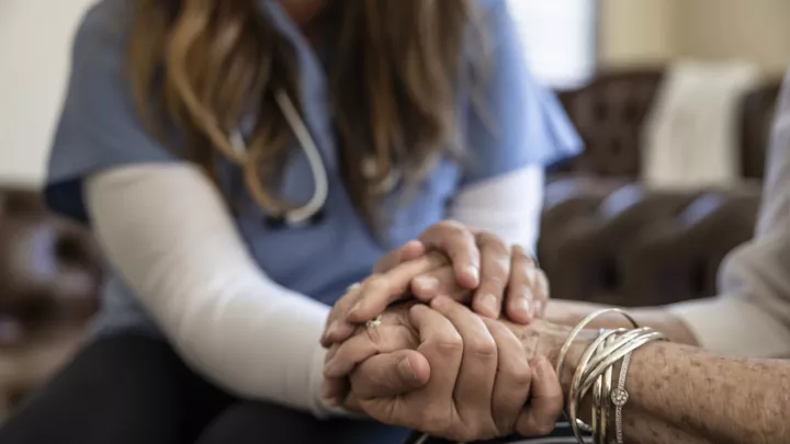 Nurse holding patient's hand