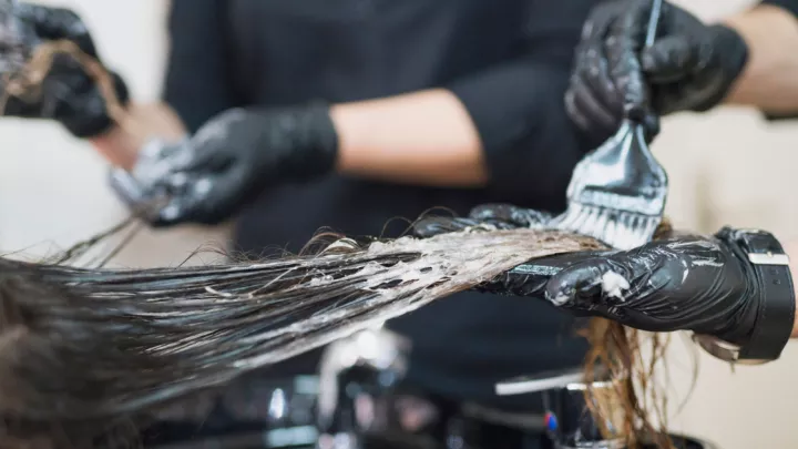 Hair stylist applying hair dye