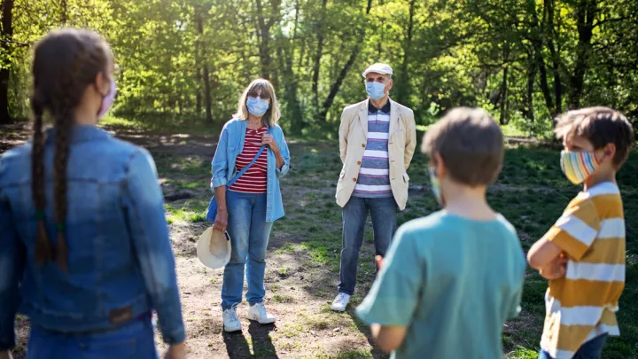 Group of people standing outside wearing masks