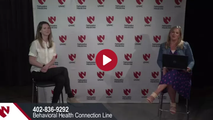 Two women are sitting six feet apart from each other.