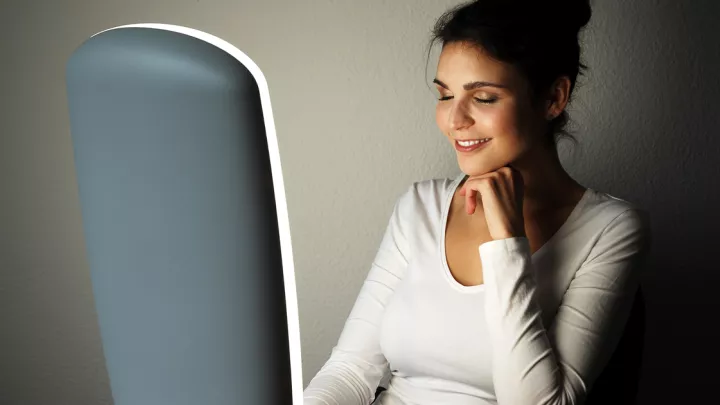 Woman sitting in front of a light