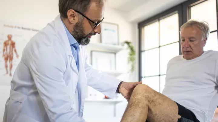 Doctor examining man's leg