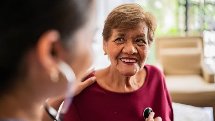 Provider listening to woman's heartbeat