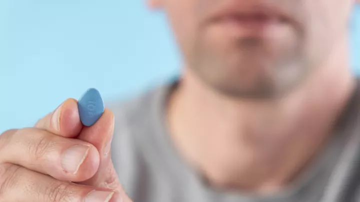 Man holding blue pill