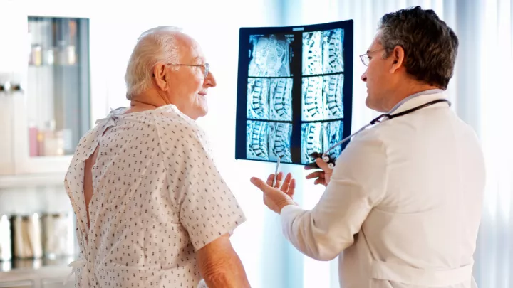 Older man looking at spine x-rays with his doctor