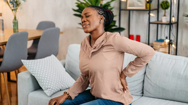 Woman holding her back in pain