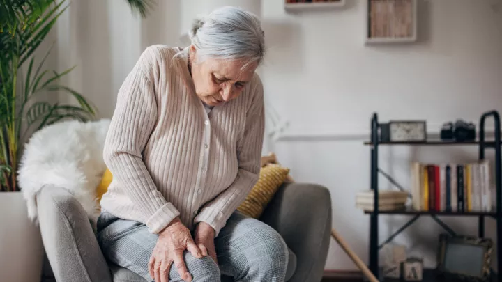 Older woman holding her knee