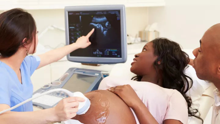 Ultrasound technician performing an ultrasound on a pregnant woman