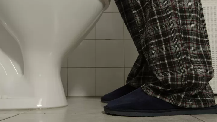 Close up of man wearing slippers using restroom