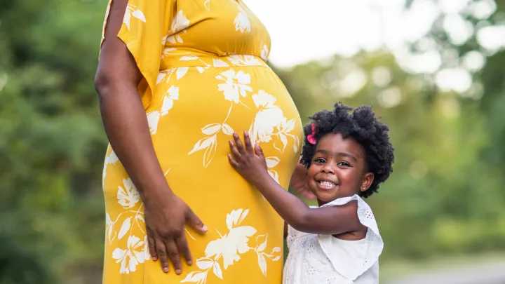 picture of a pregnant woman and her young daughter