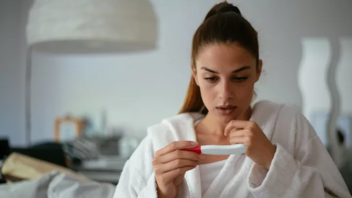 Young woman holding a pregnancy test