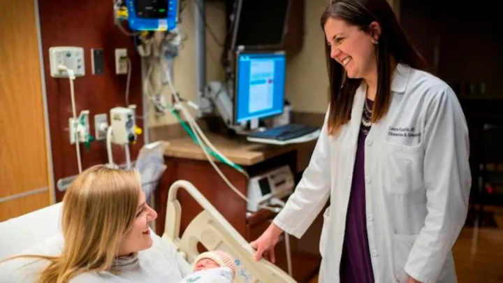 Laura Cudzilo, MD, OB/GYN with patient